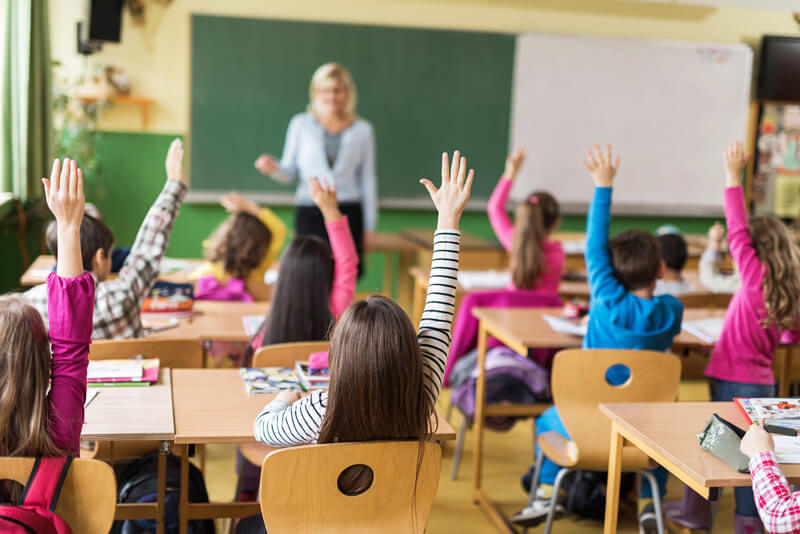 Kids raising hnds in classe
